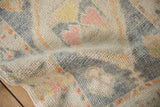Supple hand-knotted wool pile of a distressed Oushak rug in dusty blue, ivory, and yellow.