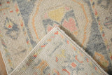 Hand-knotted foundation and soft wool pile of a distressed Oushak rug at the folded corner.