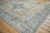 Vintage distressed Sparta carpet detail: pale ochre field, scrolling blue palmettes, and textured wear.