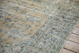 Distressed vintage Sparta carpet section with faded blue floral patterns on a pale ochre ground.
