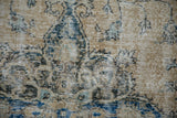 Distressed vintage Sparta carpet texture with worn pale ochre, blue, and brown pile.