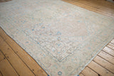 Angled view of a distressed Sparta carpet with soft blush, blue, and sage floral details.