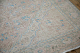 Detail of the worn, hand-knotted texture in soft blush, ivory, and powder blue.