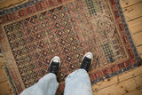 Geometric patterns of a late 19th century Caucasian rug in chocolate, cherry, and sapphire blue, with a checkered mehrab.