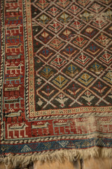 Antique Caucasian rug showing aged patina on a field of geometric plants and a cherry red border.