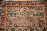 Geometric patterns and worn pile showing foundation, featuring cherry red, sapphire blue, and sand.