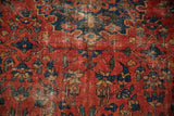 Vintage Lilihan carpet detail: red field with floral buds, vinery, and significant foundation wear.