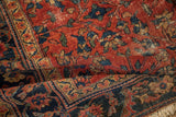 Vintage Lilihan rug showing worn cherry red field, navy floral vinery, and exposed foundation.