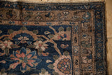 Vintage Hamadan rug runner corner with navy, brown, rose Veramin design motifs and tattered side.