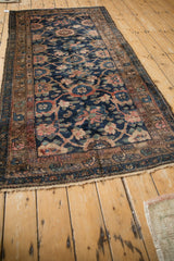 Vintage Hamadan runner corner with navy Veramin floral design and tattered fringe.