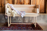 White maple sidecar styled as a modern bench with cushions and blankets.