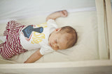 Newborn baby sleeping peacefully inside the Little Mod White Maple sidecar.