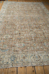 Worn pile of a distressed Sparta carpet, with faded floral blossoms and exposed foundation.