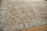 Angled detail of distressed vintage Sparta carpet, showing worn floral field and neutral border.