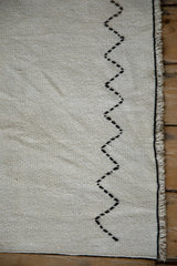 Ivory plain-weave vintage hemp kilim, with black zigzag stitch detail and neat bound side.