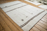 Vintage hemp kilim's beige plain weave, brown horizontal stripes, and primitive motif.