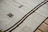 Beige plain-weave Hemp Kilim: chocolate stripes, primitive stitching, visible bound edge.