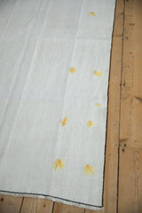 Hand-seamed panels with decorative yellow tufts on a vintage hemp kilim.