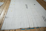 Yellow synthetic fiber tufts accenting the seamed, striped plain-weave of a vintage hemp kilim.