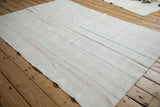 Vintage hemp kilim rug from an angle, showing its seamed panel construction and flat weave.