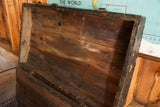 Distressed wood grain and chippy black paint inside the primitive wooden trunk lid.