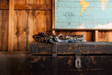 Primitive black wooden trunk showing distressed chippy paint and aged metal latch.