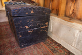 Chippy black paint and ornate iron handle on the antique primitive trunk.