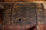 Distressed wooden trunk lid with chippy black paint and round keyhole.