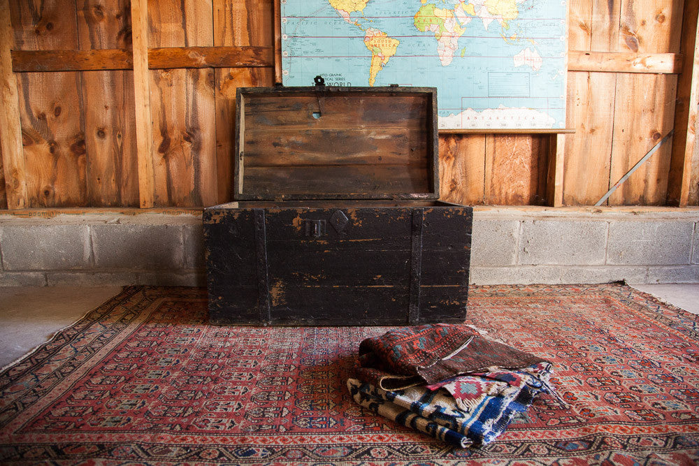 Antique Primitive Black Wooden Trunk with open humpback lid and distressed chippy paint.