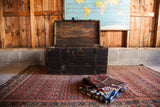 Antique Primitive Black Wooden Trunk with open humpback lid and distressed chippy paint.