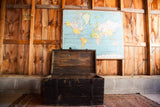 Distressed black wooden trunk open, revealing chippy paint, iron hardware, and clean wood interior.