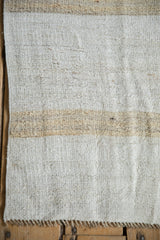Hand-woven Turkish kilim texture showing natural striped abrashes and fringe.