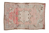 Vintage distressed Oushak rug with a serrated starburst medallion on a faded rose and silver field.