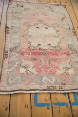 Detail of the serpent main border and distressed texture on a rose and silver Oushak rug.