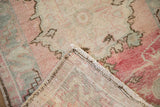 Hand-knotted foundation and secured side cord of a distressed vintage Oushak rug.