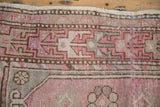 Distressed vintage Oushak rug showcasing geometric ram's horn motifs in faded plum, slate blue.