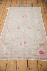 Angled view down the length of a distressed Oushak rug, highlighting its faded floral pattern.