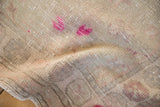 The low, hand-knotted pile of a distressed Oushak rug showing even wear and magenta accents.