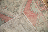 Distressed Oushak rug runner pile showing faded raspberry and sea foam green, with visible hand-knotted foundation.