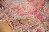 Distressed Oushak rug pile texture with faded cherry red and dusty green colors.