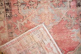 Flipped corner revealing the vintage Oushak rug's hand-knotted foundation and distressed pile.