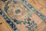 Distressed Oushak runner with abrashes, sand field, blue motifs, and visible foundation.