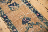 Distressed vintage Oushak runner showing sand field, visible wear, blue and pink patterns.