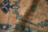 Distressed texture of vintage Oushak runner pile, showing sand, cobalt blue, and pink patterns.