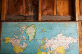 Upper section of vintage 1930s pull down map, blue oceans, yellow-green land, aged canvas.