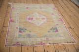 Distressed vintage Oushak rug featuring a magenta stepped medallion on a time-softened gold field.