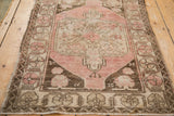 Textured pile of a distressed vintage Oushak rug, revealing dusty blush, brown, and ivory patterns.