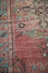 Distressed Oushak runner close-up: blush, pale blue, cream floral motifs with foundation visible.