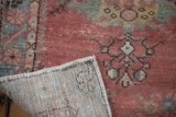 Distressed blush Oushak runner's worn pile, visible side selvage, and hand-knotted foundation.