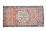 Distressed vintage Oushak runner with faded rose abrash, dusty blue border, and vibrant floral medallion.